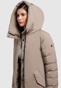 Béžová prešívaná bunda s veľkou kapucňou, zapínaním na gombíky a zips, bočnými vreckami a hladkou, lesklou textúrou.