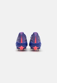 Scarpe da calcio viola con tomaia in mesh testurizzato, dettagli rosa e un tacco brillante a forma di stella rosa, dotate di tacchetti metallici per una migliore trazione.