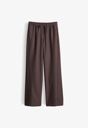Bruine broek met wijde pijpen gemaakt van een gladde stof, voorzien van een elastische tailleband en trekkoord. Heeft twee zijzakken en geen zichtbare patronen.
