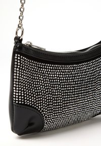 Borsa nera con tracolla a catena argentata, ricoperta di piccoli chiodini riflettenti argentati e con una cerniera argentata visibile sulla parte superiore.