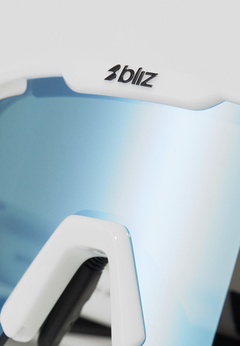 Białe sportowe okulary przeciwsłoneczne z lustrzanym niebieskim szkłem, trójkątnymi akcentami na oprawie oraz czarnym logo "bliz".