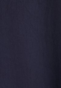 Gros plan d'un tissu bleu foncé avec une fine texture côtelée diagonale.