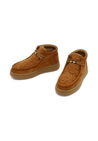 Bruine suède enkellaarzen met een textuur die lijkt op bont, vetersluiting en kleurrijke kralenaccenten op de veters. Rubberen zool voor grip.