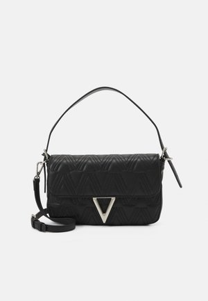 Sac à bandoulière en cuir matelassé noir avec fermoir triangulaire argenté, poignée courte et bandoulière réglable amovible sur fond blanc.