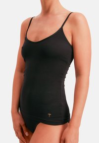 Canotta nera in tessuto morbido, con spalline sottili e scollo arrotondato. Include un logo dorato discreto nella parte inferiore.