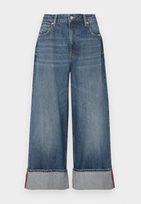 Jeans de mezclilla de pierna ancha en un lavado azul intermedio, con una cintura alta, cinco bolsillos, costuras en contraste y puños doblados con acentos rojos.