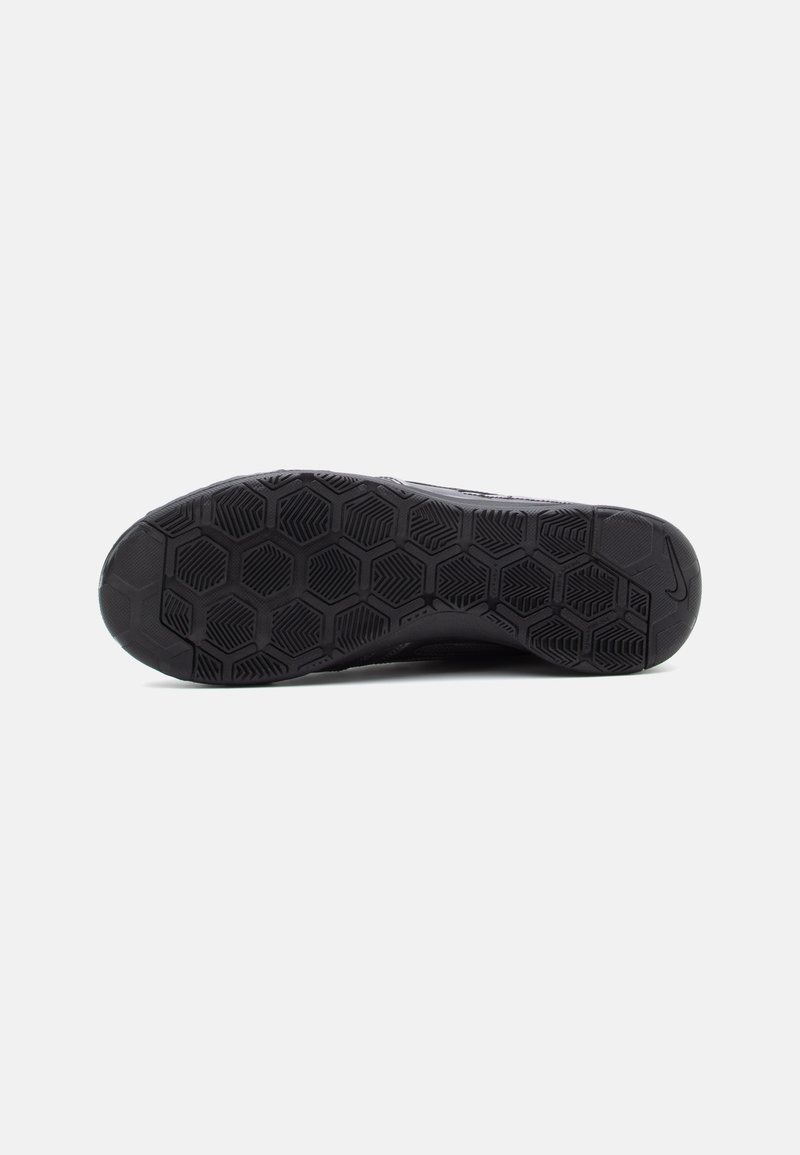 Schwarze Sportschuhsohle mit einem Wabenprofil, aus Gummi gefertigt, mit einer glatten Oberfläche und runder Zehenform.