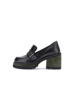 Scarpa in pelle nera con un tacco a blocco in suede verde chunky. Presenta una fibbia decorativa e una silhouette a punta arrotondata con suola testurizzata.