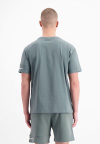 Korte mouwen T-shirt van gedempt groene katoen, met een ronde hals en een eenvoudige achterkant, gecombineerd met bijpassende shorts.