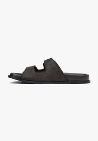 Brown fur slide sandal with an open toe, featuring a cut-out design and a contrasting dark sole. Minimalist gold accent near the strap.