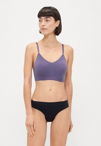 Bralette viola con spalline sottili e bordo in pizzo; abbinato a culotte nere a vita bassa. Tessuto morbido e design semplice per il massimo comfort.
