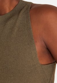 Top senza maniche verde oliva, con trama a coste, scollo rotondo e lati aperti, che mette in risalto una silhouette aderente.