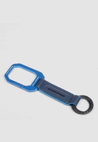 Portachiavi blu con un telaio in alluminio ottagonale e un cinturino in pelle blu scuro. Presenta un anello di metallo per attaccare le chiavi.