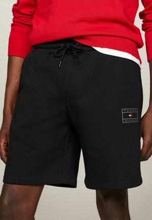 Schwarze Baumwollshorts mit elastischem Bund und Kordelzug. Mit einem Tommy Hilfiger Logo-Patch. Glatte Textur und knielanger Schnitt.