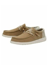 Zapatos de tela color marrón claro con una parte superior texturizada, suela de goma blanca, cordones en contraste y un forro interior con patrón.