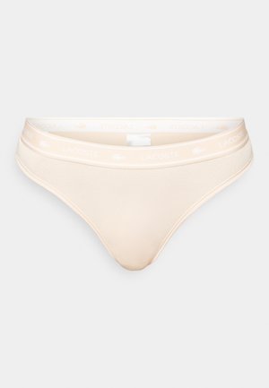 Cuecas bikini de algodão bege com uma cintura elástica suave, apresentando o logótipo branco da Lacoste, textura suave e um design de corte clássico.