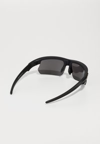 Schwarze Sportsonnenbrille mit envelopierendem Design, dunkel getönten Gläsern, flexiblem Kunststoffrahmen und strukturierten Gumminiaugestützen für besseren Halt.