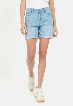 Shorts en jean bleu clair avec ourlets roulés et design à cinq poches. Associés à des baskets blanches avec une tige texturée et un système de laçage.