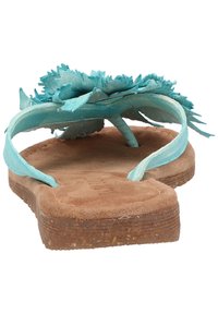 Turkoosit varvastossut, joissa on kukkakuvio hihnoissa, mokkanahkainen pohjallinen ja kuvioitu ruskea pohja.