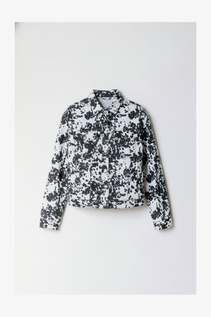 Jachetă din denim cu pete alb-negru, cu mâneci lungi, guler ascuțit, două buzunare la piept, închidere cu nasturi și design scurt.