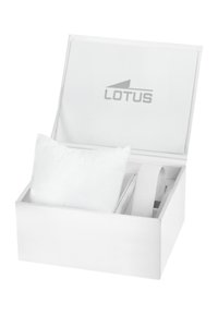 Balta stačiakampė dėžutė su dangčiu, viduje esantis minkštas baltas paminkštinimas ir pilkas elastingas diržas. Ant vidinio dangtelio spausdintas "LOTUS" logotipas.