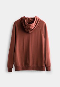 Felpa color ruggine con una texture morbida, dotata di un cappuccio ampio, polsini e orlo a costine. Maniche raglan e dettagli di design minimal.