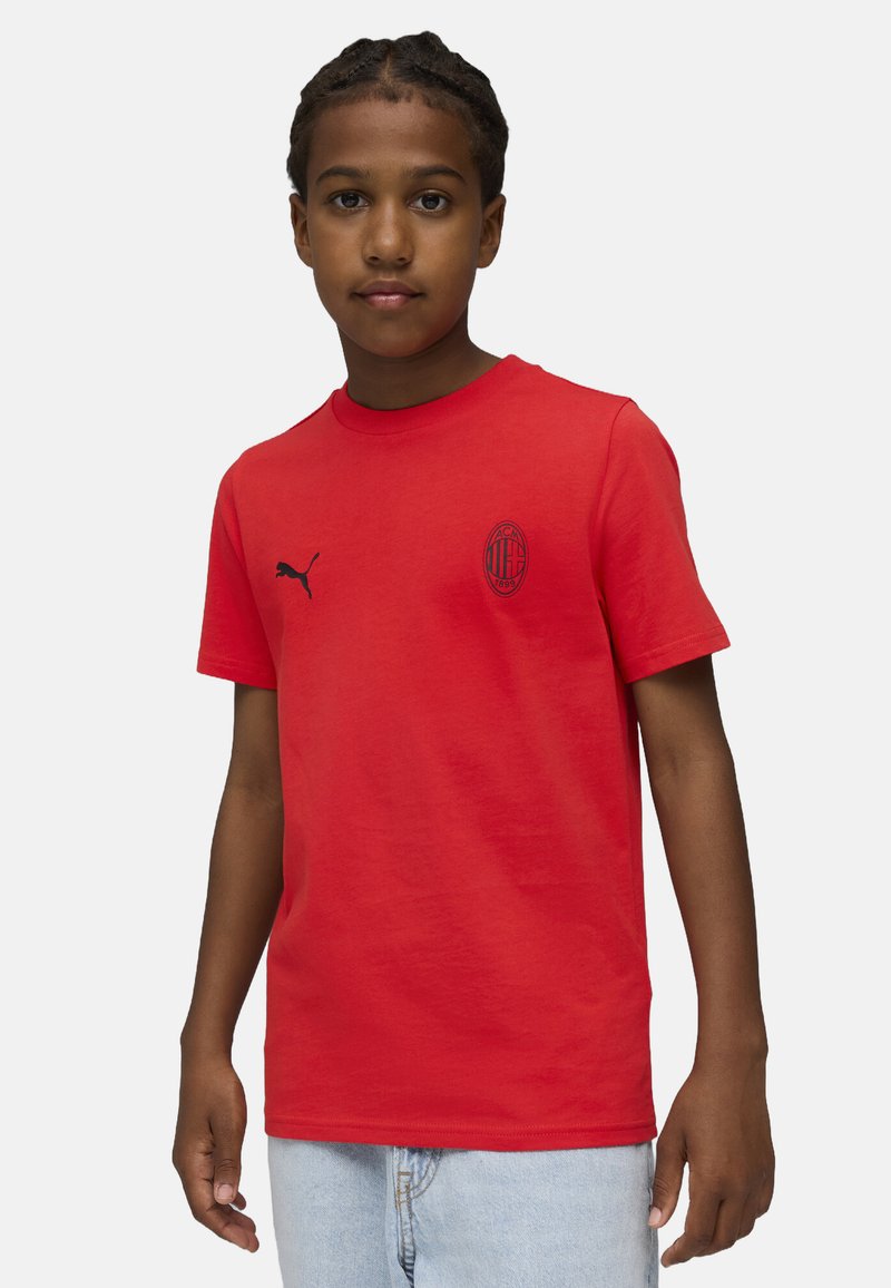 Röd bomullströja med rund halsringning, korta ärmar, svart Puma-logotyp och AC Milan-emblem på vänster bröst. Slät textur.