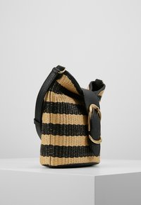 Randig vävd handväska i naturliga och svarta material, med en böjd form, svarta läderdetaljer och en guldtonad spännvid.