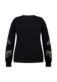 Zwarte sweater met lange mouwen, voorzien van ingewikkelde crèmekleurige borduursels langs de mouwen en een geribde manchette en tailleband.