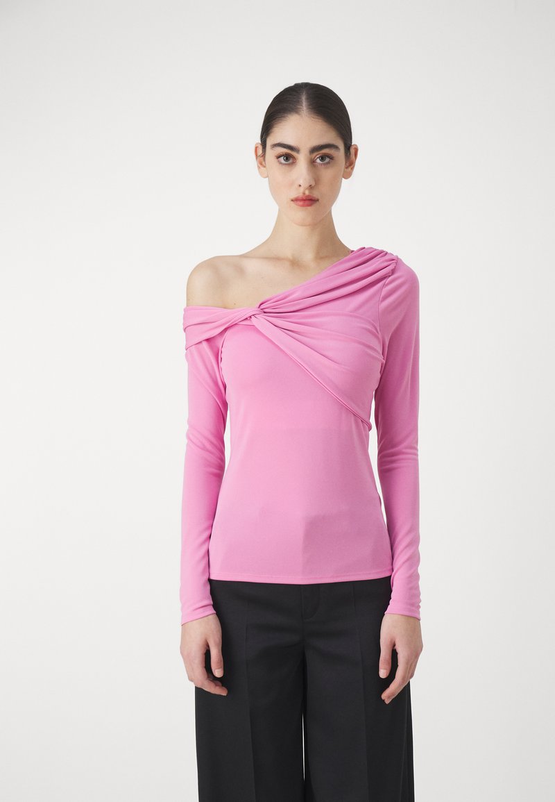 Haut ajusté à manches longues en rose vif, avec un design asymétrique d'épaule dénudée et un détail de tissu drapé sur la poitrine.