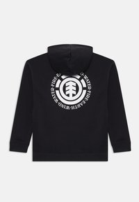 Felpa nera con cappuccio e una grafica circolare bianca sul retro che presenta simboli elementali: terra, fuoco, acqua e vento.