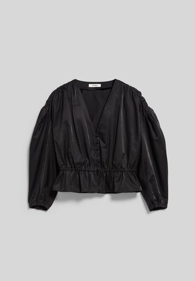 Blouse noire à manches longues avec encolure en V, boutonnée à l'avant, taille froncée et épaules bouffantes sur un fond gris clair.