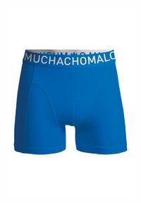 Calzoncillos boxer azules para hombre, hechos de una tela suave, con un ajuste ceñido y una cinturilla elástica blanca con la inscripción "MUCHACHOMALO" en azul.