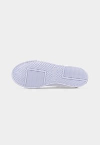 Λευκή σόλα αθλητικού παπουτσιού με σχέδια στραβοβελονιάς και ορθογώνιας χάραξης, με το λογότυπο της Lacoste ανάγλυφο στο κέντρο.