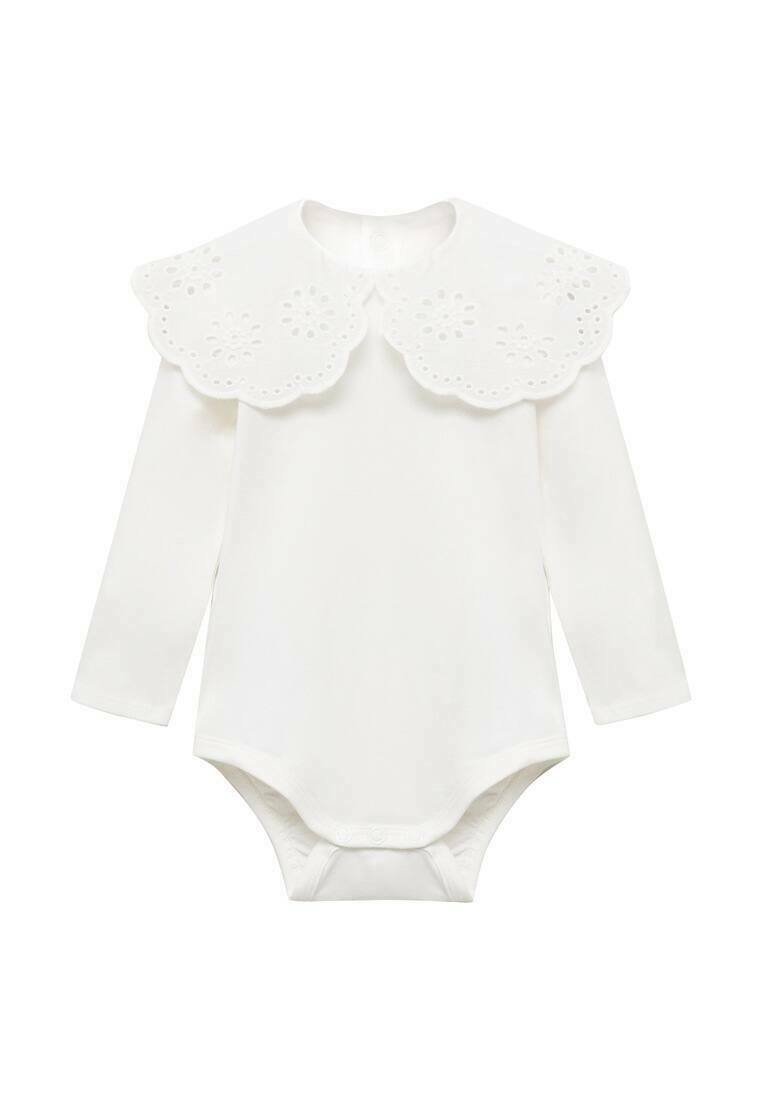 Valkoinen pitkähihainen bodysuit, jossa on suuri aaltoileva kaulus, jossa on koristeellisia rei'itettyjä kuvioita. Pehmeää kangasta, jossa on nepparikiinnitys alhaalla.