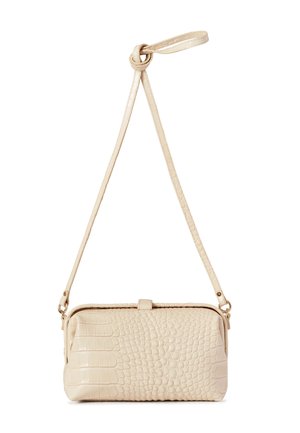 Pequeño bolso beige de bandolera con textura grabada de cocodrilo y una correa larga ajustable anudada en la parte superior.