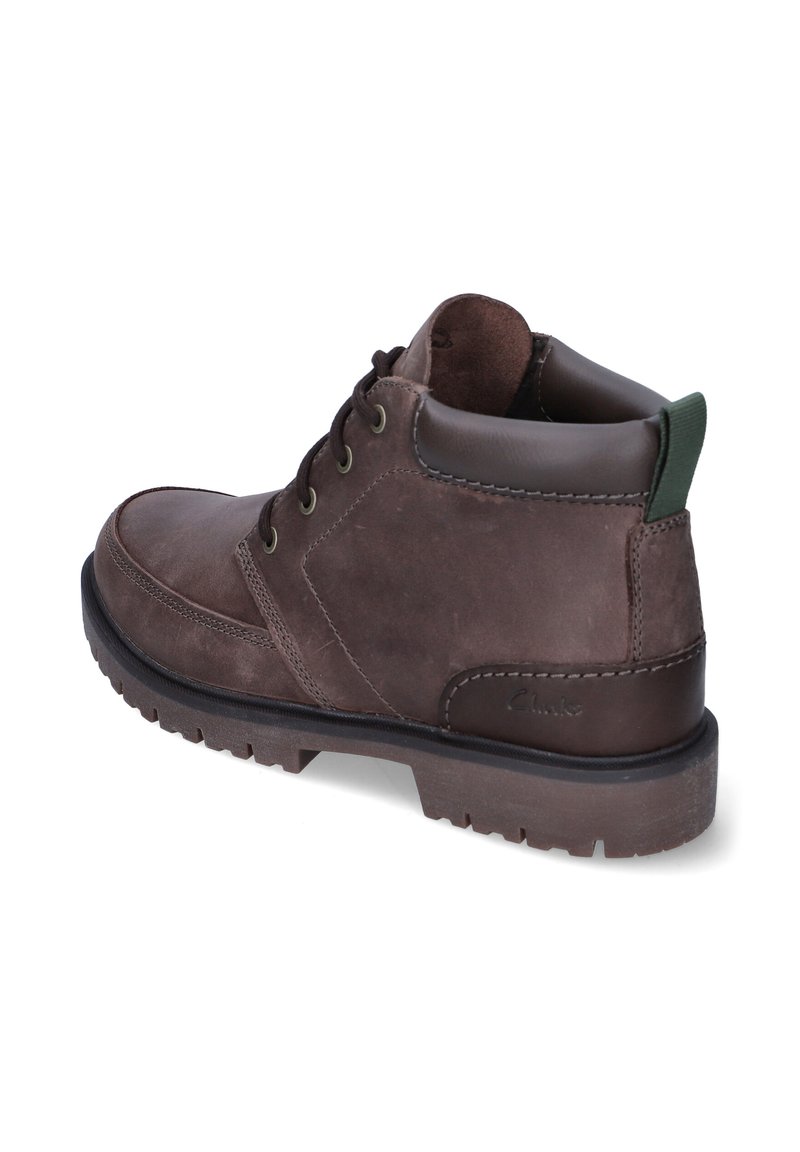 Bottine en cuir marron avec une finition texturée, bout rond, lacets à l'avant et accent vert sur le talon. Présente une semelle en caoutchouc robuste.