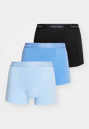 Drie paren Calvin Klein boxershorts in zwart, lichtblauw en donkerblauw, met zacht materiaal en elastische taillebanden met logo.