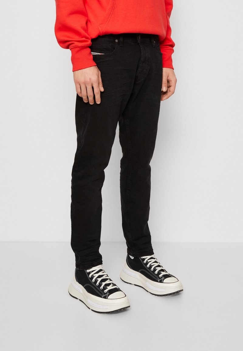 Svarta slim-fit jeans i denim, med en klassisk femfickorsdesign och en slät yta. Kombineras med kraftiga svartvita sneakers.