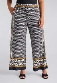 Zwart-wit gestreepte wijde broek met een trekkoord in de taille, met een accentrand in goud en geometrische ontwerpen.