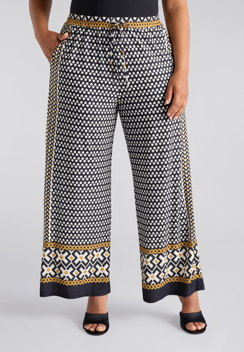 Zwart-wit gestreepte wijde broek met een trekkoord in de taille, met een accentrand in goud en geometrische ontwerpen.