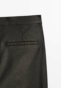 Svart kjoltyg med en mjuk textur, som har en sydd ficka på baksidan. Midjebandet är slätt, med en ren finish.