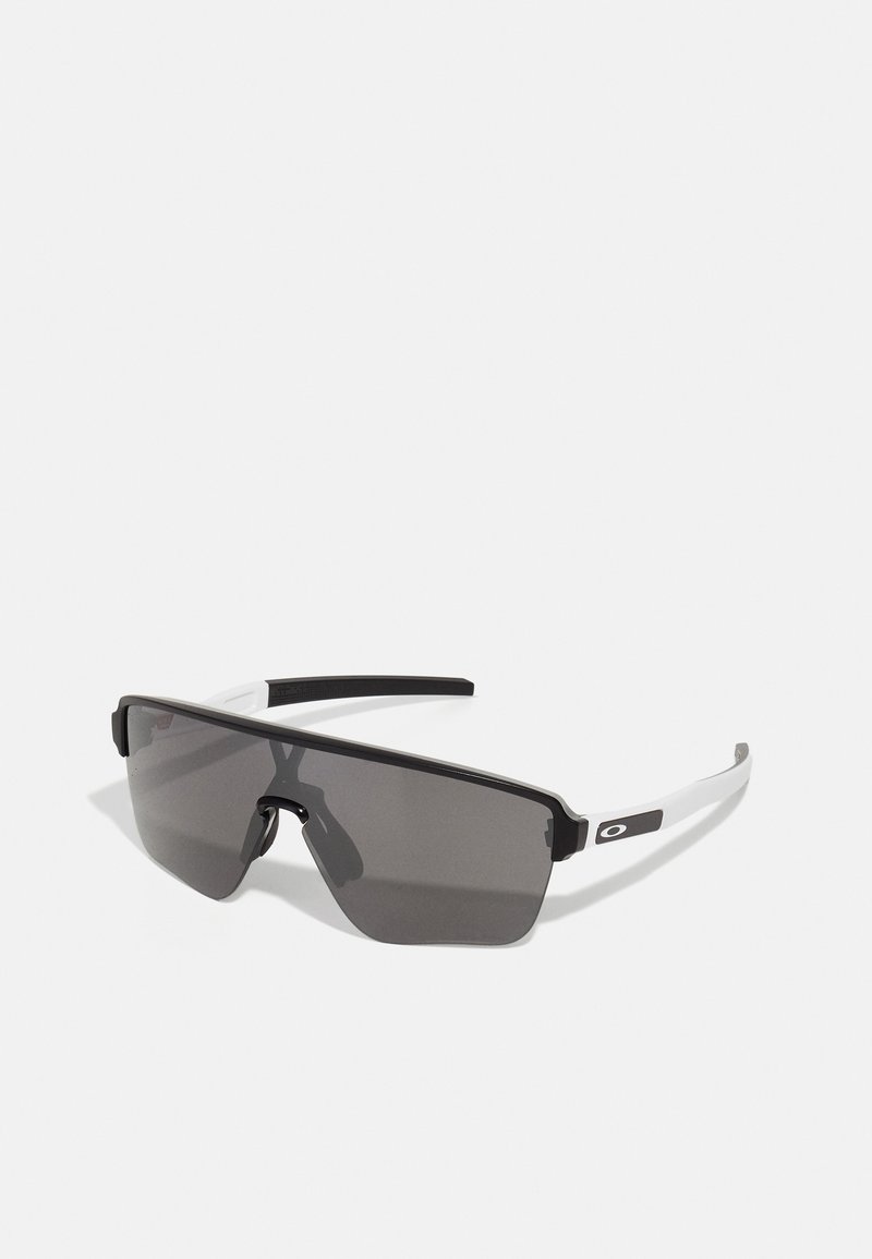 Óculos de sol pretos e cinzentos com um design grande e angular. Apresentam um acabamento mate e detalhes brancos nas hastes. Lentes de tonalidade escura.