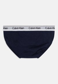 Námořnické bavlněné trenýrky s bílým elastickým páskem, na kterém se opakuje logo "Calvin Klein" v černé barvě. Hladký povrch a tvarované provedení.