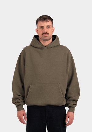Felpa verde oliva con tasca frontale, vestibilità oversize e cordoncino. Realizzata in tessuto morbido, presenta polsini e orlo a costine.