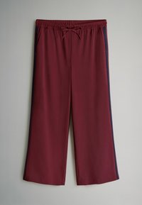 Burgundské športové nohavice s elastickým pásom, šnúrkou a bočnými námorníckymi prúžkami. Vyrobené z hladkej, ľahkej tkaniny.