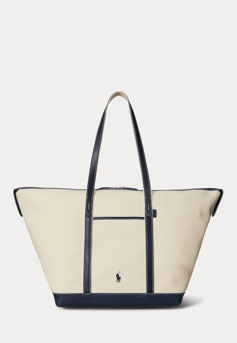 Beige og navy canvas-tote taske med lange håndtag, en forlomme og et lille broderet hest og rytter-logo foran.