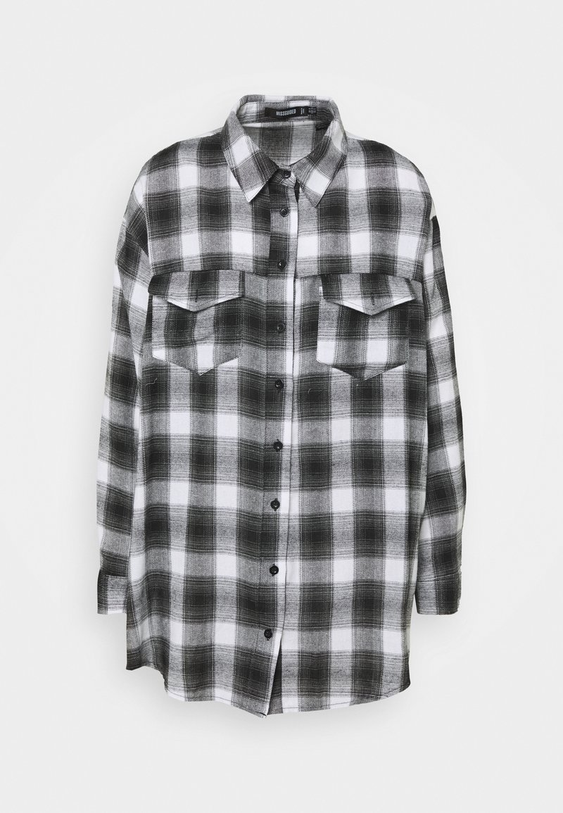 Mustalla ja valkoisella ruudullinen flanellipaita, jossa on kaulus, kaksi rintataskua, pitkät hihat ja napitettava etuosa. Pehmeä kangas.