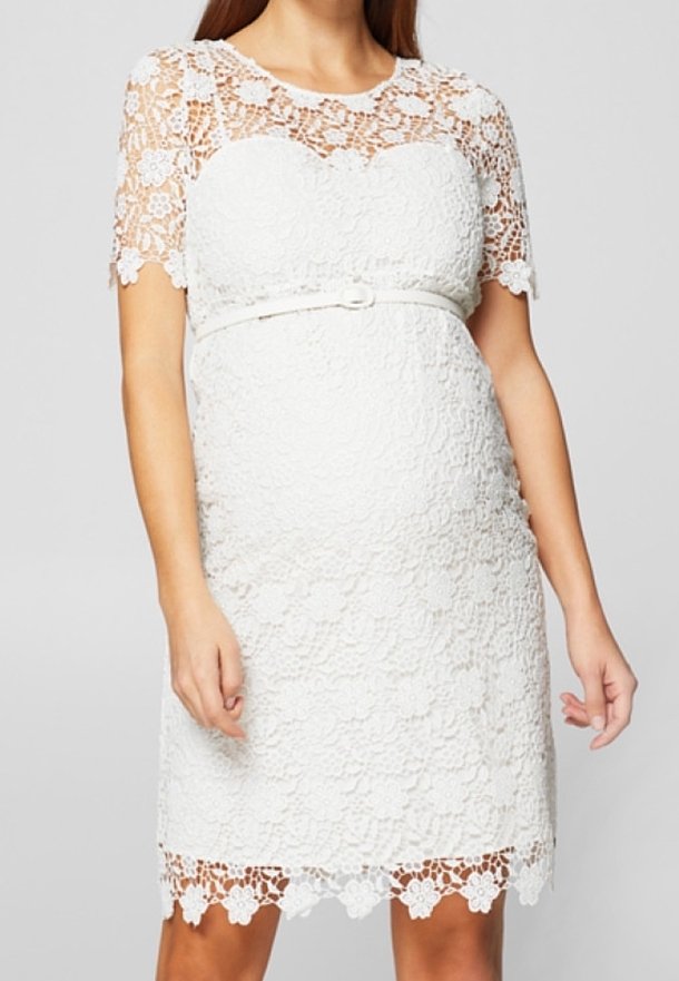 Vitt spetsklänning med korta ärmar, blommönster, figursydd bodice och resårmidja. Innehåller detaljer med vågkantade fållar. Midilängd.