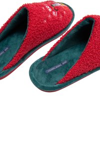 Zapatillas rojas y esponjosas con un interior verde, diseño tipo slip-on y superficie texturizada. La plantilla muestra la etiqueta de la marca "Ysabel Mora".